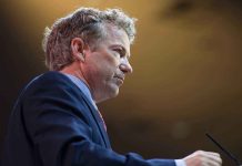 A man in a suit speaking at a podium during a conference