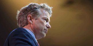 Rand Paul WARNS: Military Strikes Prelude to War A man in a suit speaking at a podium during a conference