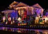 A house decorated with colorful Christmas lights and festive figures