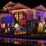 A house decorated with colorful Christmas lights and festive figures