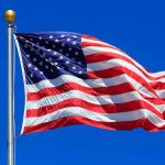 Waving American flag against a clear blue sky
