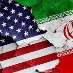 Cracked American and Iranian flags on a wall.