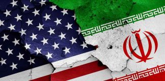 Cracked American and Iranian flags on a wall.