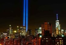 New York City skyline at night with memorial lights.