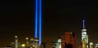 911 Memorial Sparks Fight New York City skyline at night with memorial lights.