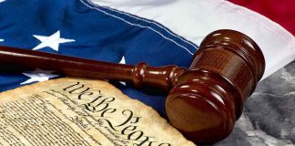 Gavel and U.S. Constitution on American flag background.