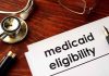 Stethoscope pen document about Medicaid eligibility on table