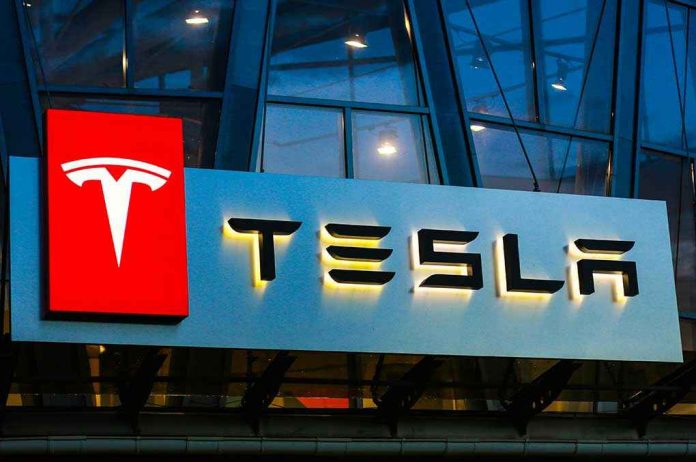 Tesla logo on a building at night.