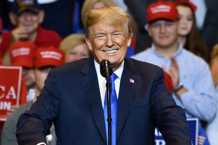 1155247306 Man in suit speaking at rally with red hats.