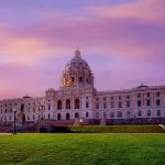 Historic building with dome under a pinkish-purple sky.