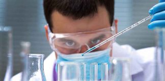 Scientist conducting an experiment with blue liquids in a laboratory