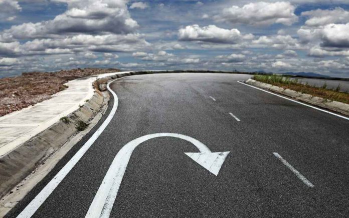 158166083 Curved road with a U-turn arrow marking.