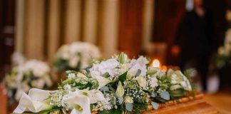 PALACE Wall SEALS Princess’s Death SECRECY Flower arrangement on a wooden casket at a funeral.