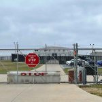 Marine Base LOOSEY GOOSEY — Then it GETS BIZARRE! Chain-link fence with Restricted Area Stop No Photography sign.
