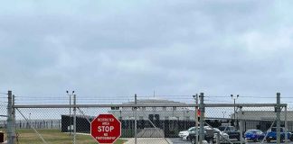 Marine Base LOOSEY GOOSEY — Then it GETS BIZARRE! Chain-link fence with Restricted Area Stop No Photography sign.
