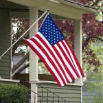 HOA Slaps FINES Over FLYING Old Glory — WHAT?? American flag hanging on a porch.
