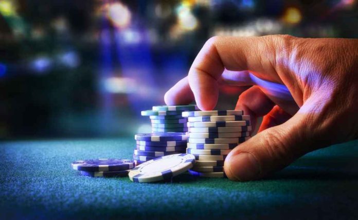betting-game-chips2408680901jpg Hand stacking poker chips on casino table