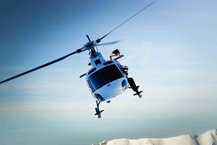 shutterstock_116155468-1- A helicopter flying over a mountainous landscape against a blue sky