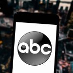 On-Air BOMBSHELL Stuns ABC A smartphone displaying the ABC logo against an urban backdrop