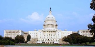 Congress JUST PRIORITIZED SPENDING Abroad Over AMERICA View of the U.S. Capitol building with a security barrier in front
