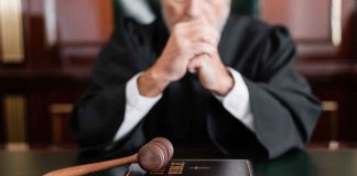A judge in a courtroom with a gavel and a Holy Bible on the table