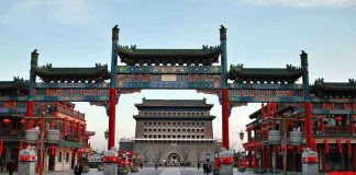 A vibrant traditional Chinese gateway with ornate decorations in an urban setting