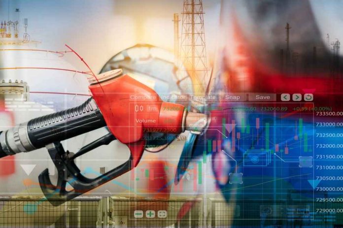 shutterstock_2252977851-1 Gas pump with financial data overlay and oil refinery in the background
