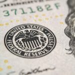 FED KING DIES — HOW HE SHAPED AMERICA Close-up of a United States dollar bill featuring the Federal Reserve emblem