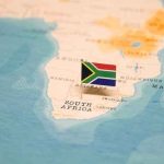 A small South African flag placed on a map of Africa