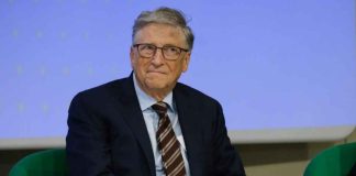 A man in a suit sitting on a green chair during a conference