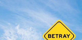 A yellow warning sign with the word 'BETRAY' against a blue sky