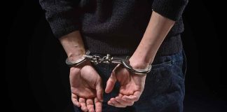 Person's hands cuffed behind their back