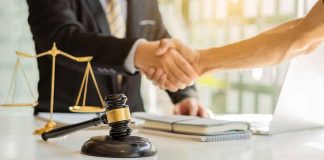 Judge Slams ‘FRAUD’ Deal Protecting Trump Hands shaking over legal documents with gavel and scales.