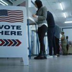 Duplicate Ballots Again! — What Are They THINKING?! Sign reading Vote Here in a polling station.