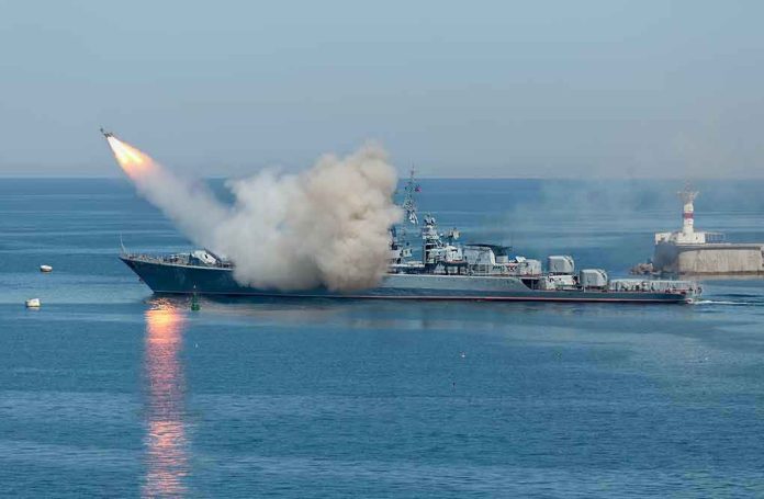 533229181 Warship firing missile in the sea.