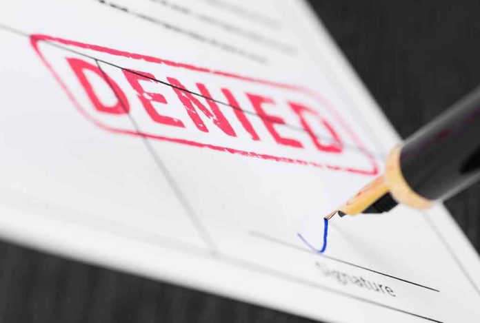 shutterstock_1058833358 Fountain pen signing a form marked denied