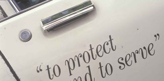 Police HQ HORROR Raises Chilling Question Close-up of a police car door with the phrase to protect and to serve