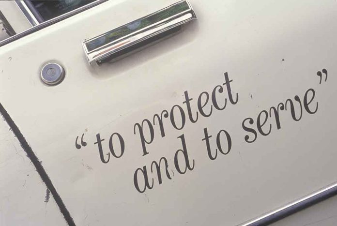 shutterstock_106869842 Close-up of a police car door with the phrase to protect and to serve