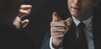 Abuse Firestorm ENGULFS GOP Rising STAR Man in suit pointing a finger during a tense conversation