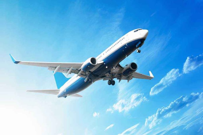 shutterstock_111203738 An airplane flying against a clear blue sky with clouds