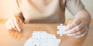 Chilling CHOICE Or BROKEN Brain? Person holding puzzle piece over head-shaped jigsaw on table