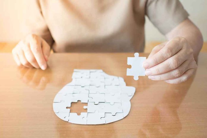 Person holding puzzle piece over head-shaped jigsaw on table
