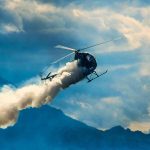 Scenic Demo SPIRALS Into Mayhem Helicopter releasing smoke over mountains