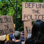 Protesters holding cardboard signs at a demonstration