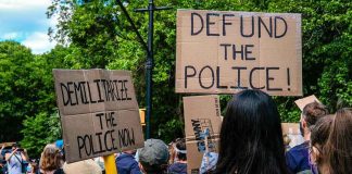 Knife Claim, No Bodycams, 1 DEAD Protesters holding cardboard signs at a demonstration