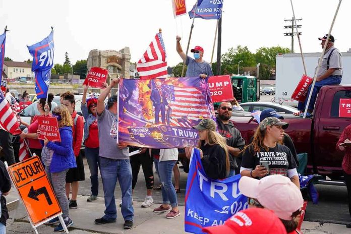 Crowd of people at a political rally holding flags and signs