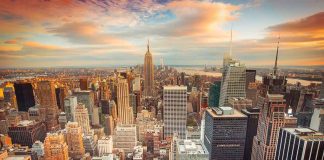 City Hall SCRUBS Little Italy Off The MAP — Why Now? Aerial view of New York City skyline during sunset with skyscrapers and clouds