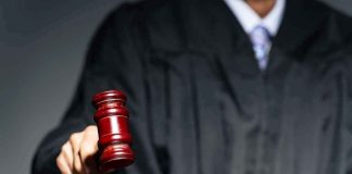 Judge with gavel striking sound block