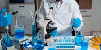Mystery PARASITE Sickens Michigan — No RECALL YET Scientist in a lab working with blue liquids and a microscope