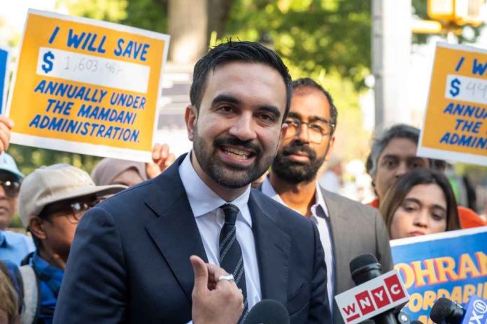 shutterstock_2686923183 A man speaking at a rally with supporters holding protest signs